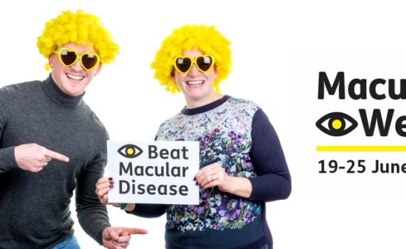 2 men with yellow wigs and sunglasses holding poster saying beat macular disease